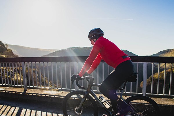 Male road rider wearing red Castelli top riding in the mountains